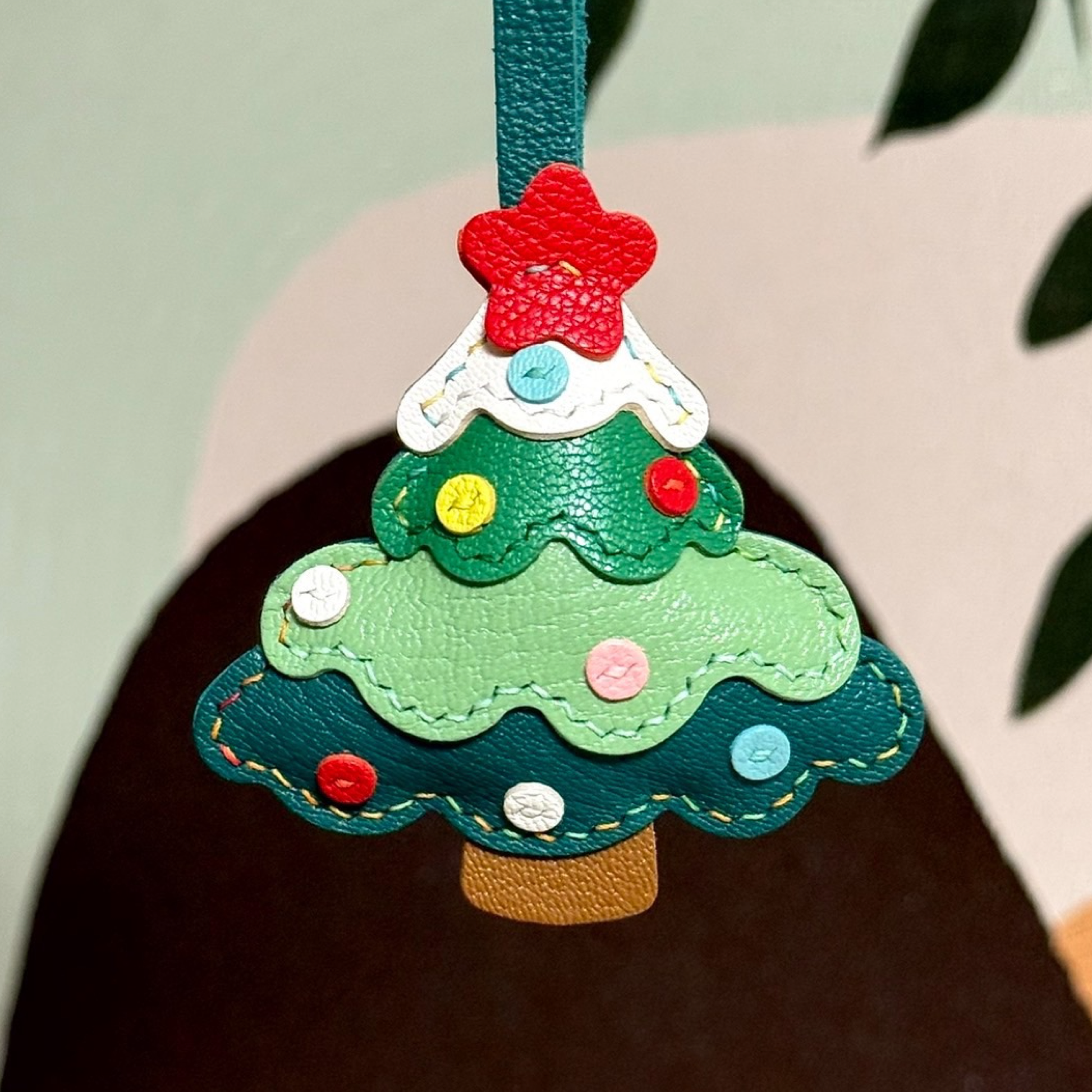 Colorful Christmas tree leather bag charm featuring festive details...